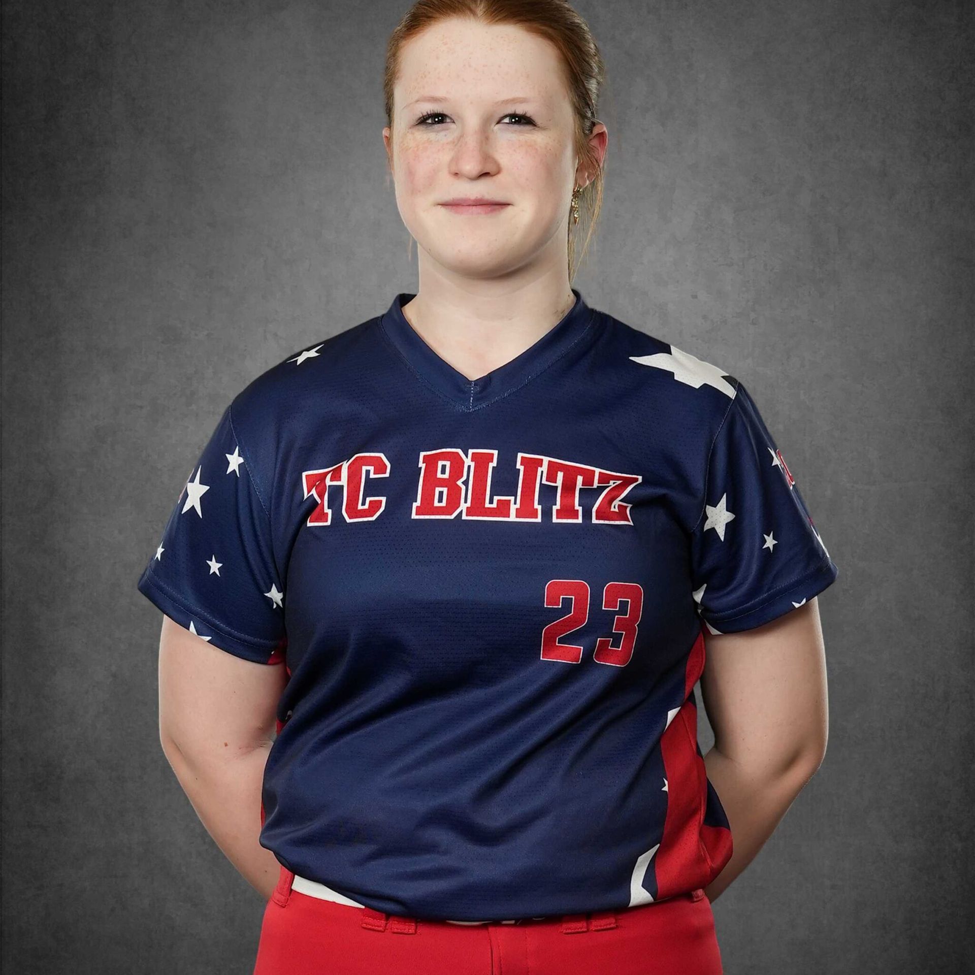 Portrait of a person in a navy and red FC Blitz jersey against a gray studio backdrop