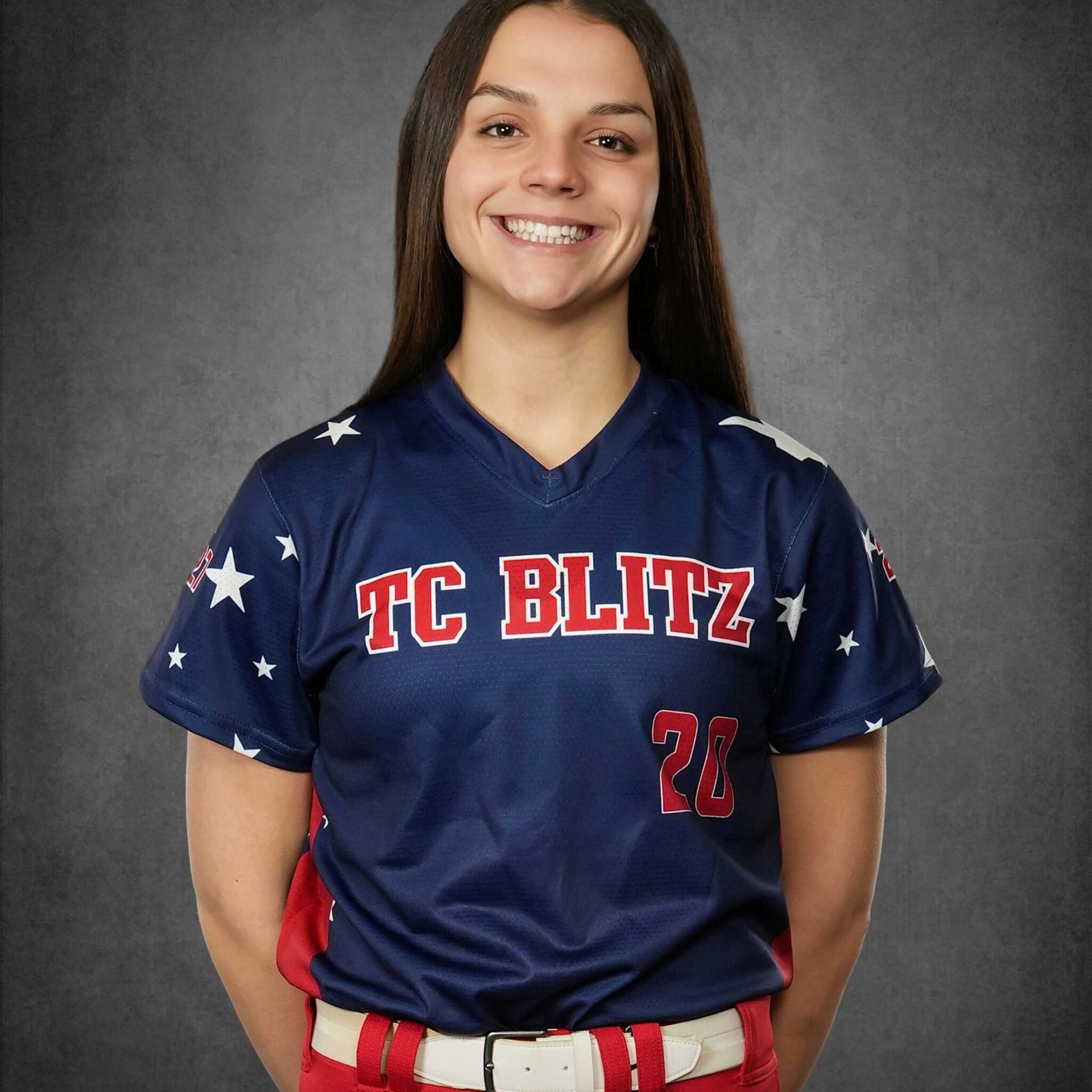 Smiling softball player in navy TC BLITZ jersey against a gray backdrop