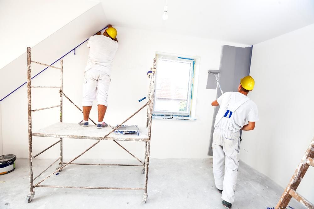 Two Men Are Painting a Wall in a Room — Capital Ultimate Facility in Tuggeranong, ACT