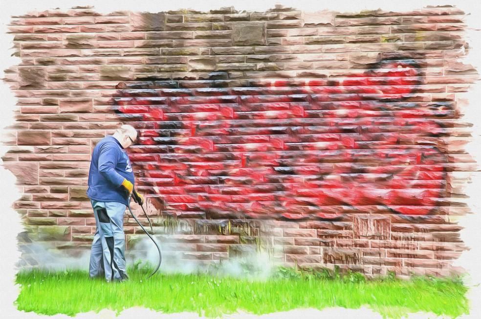 Man is Spraying Red Paint on a Brick Wall — Capital Ultimate Facility in Woden, ACT