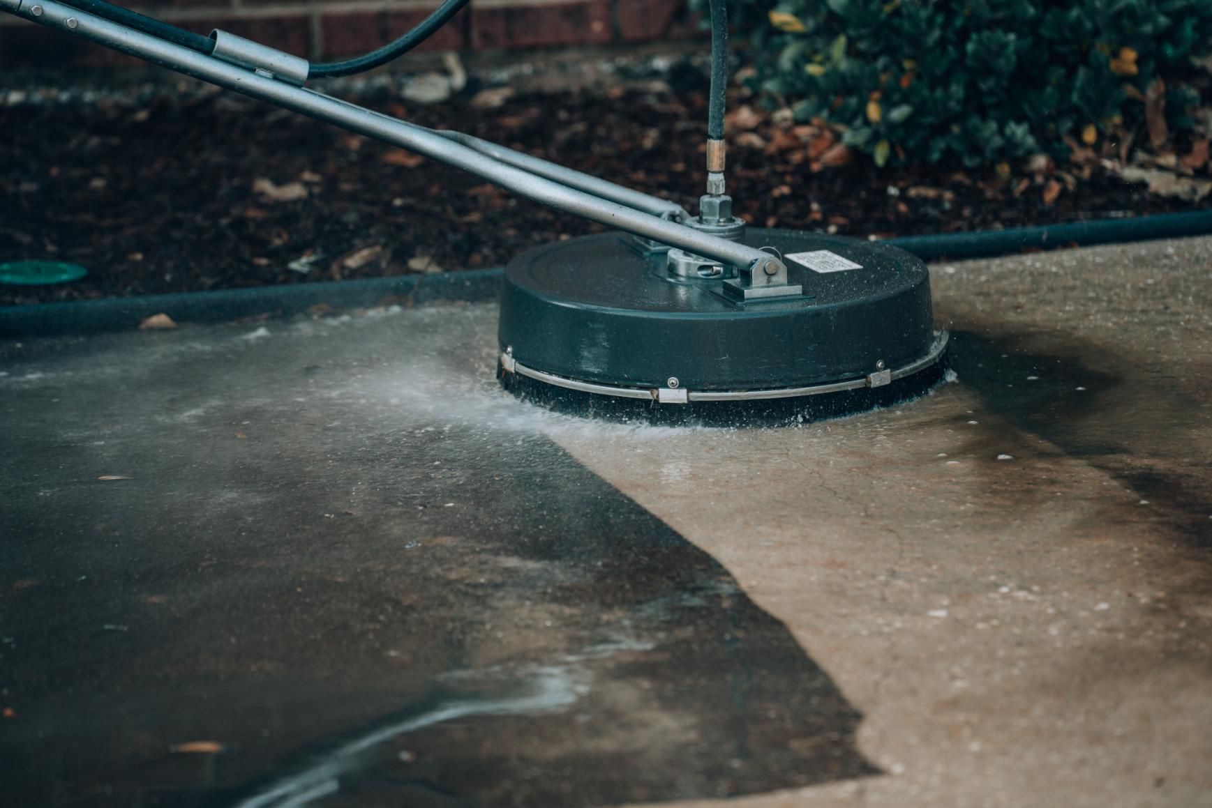 Person is Cleaning a Concrete Driveway With a Machine — Capital Ultimate Facility in Canberra, ACT