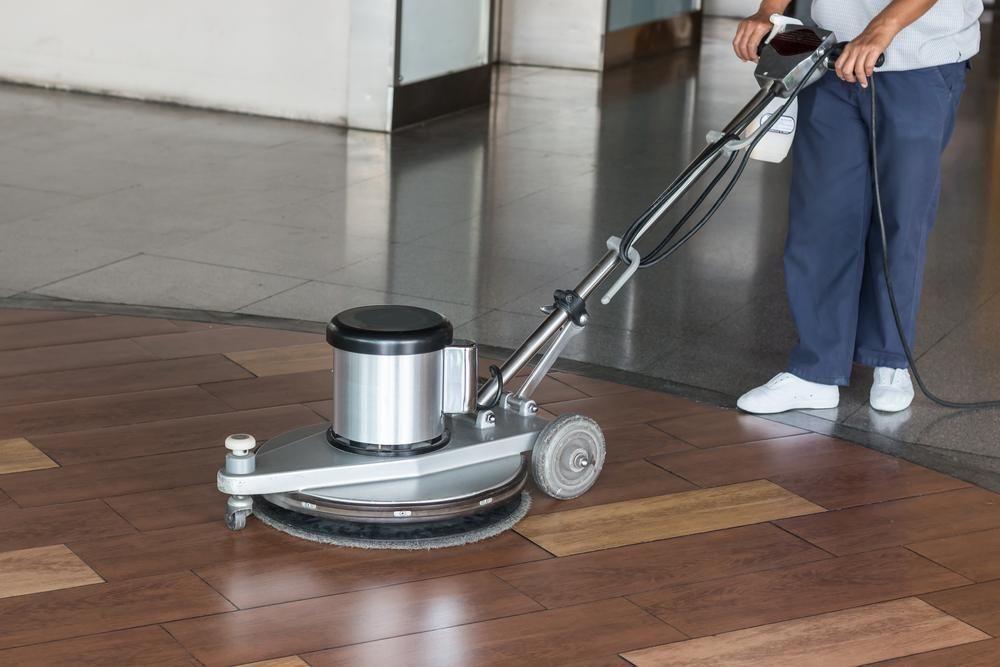 Person is Using a Machine to Clean a Wooden Floor — Capital Ultimate Facility in Beard, ACT
