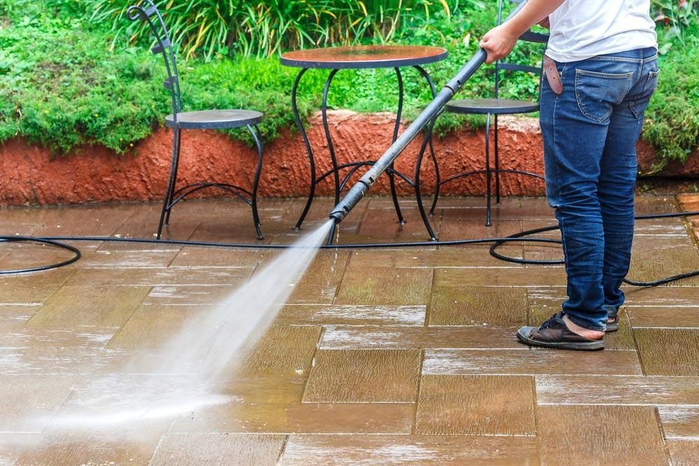 Man is Using a High Pressure Washer to Clean a Patio — Capital Ultimate Facility in Belconnen, ACT
