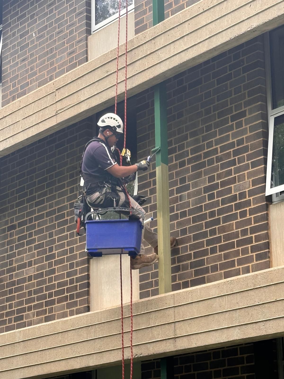 Man is Painting a Pink Wall With a Brush — Capital Ultimate Facility in Beard, ACT