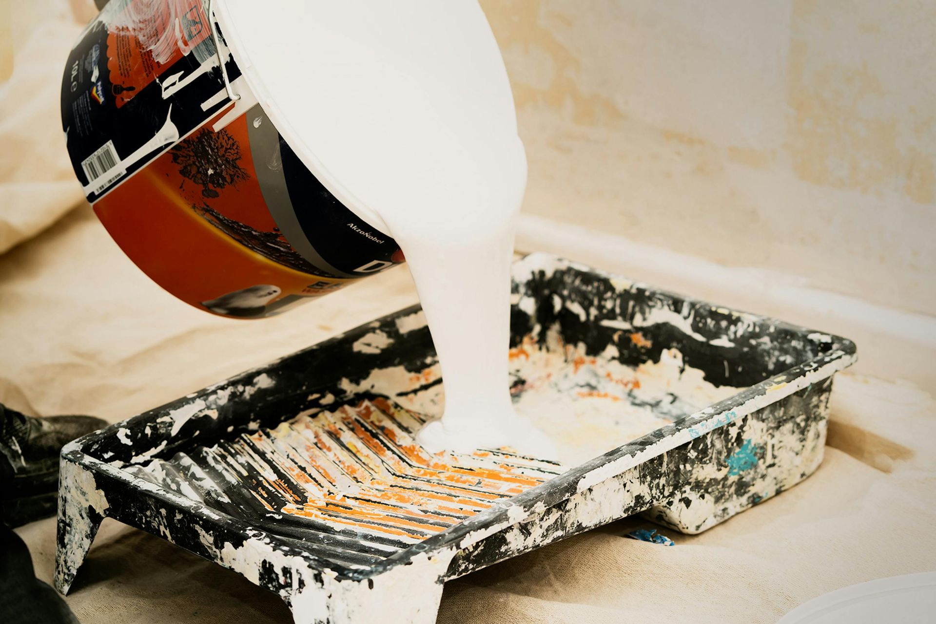 A person is pouring paint into a paint tray — Capital Ultimate Facility in Beard, ACT