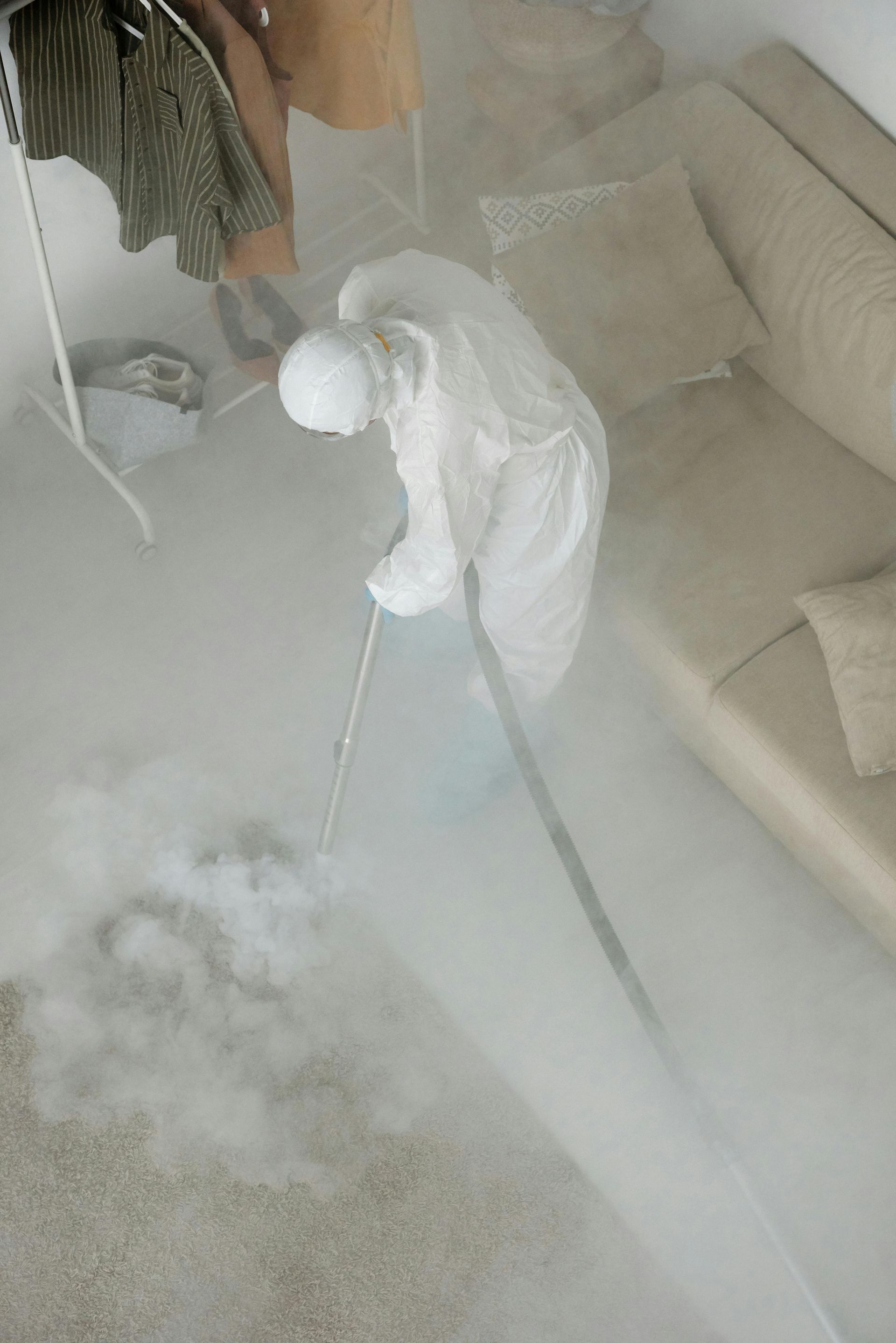 A person is cleaning a carpet with a vacuum cleaner in a living room. — Capital Ultimate Facility in Woden, ACT