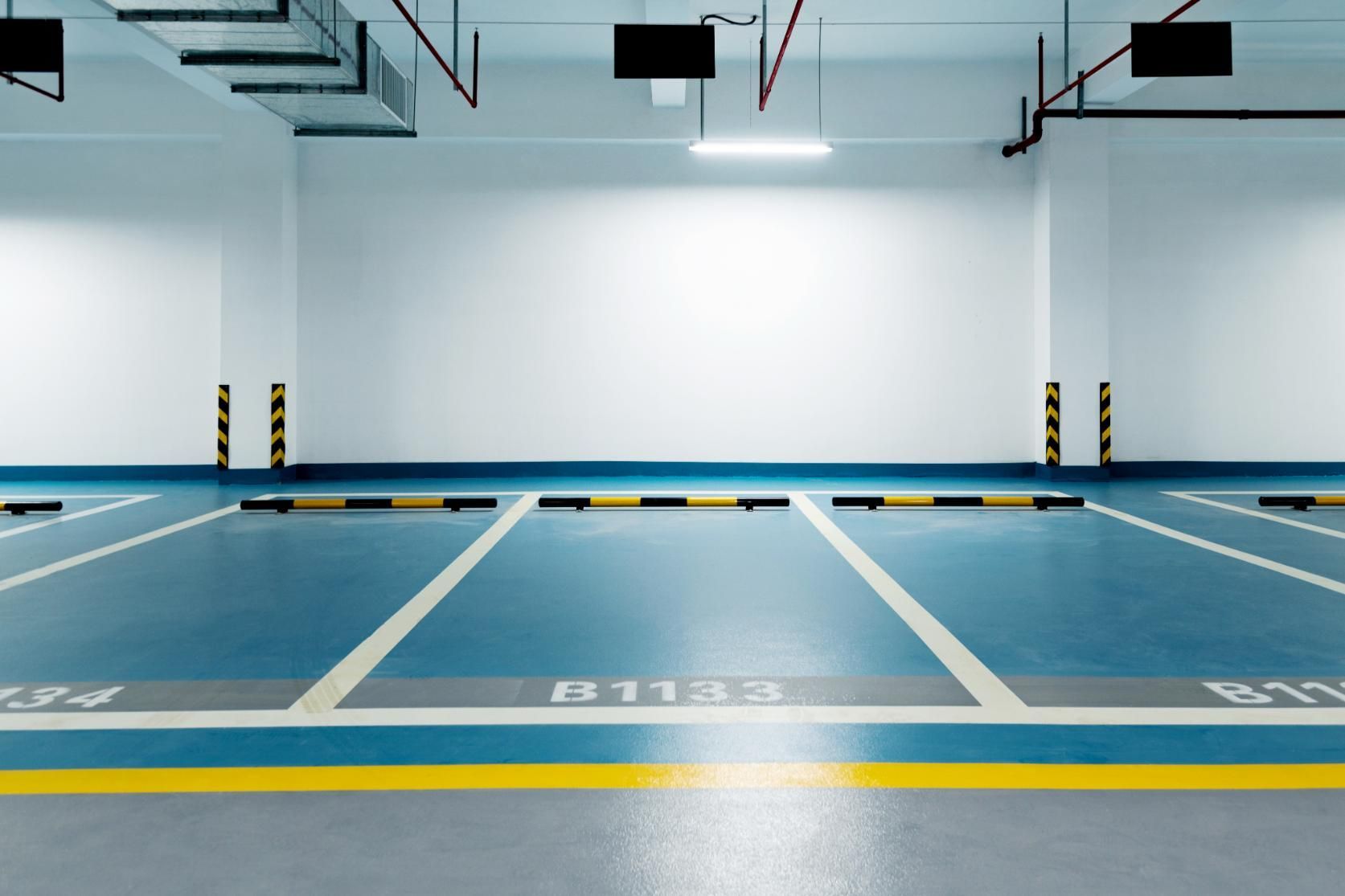 An Empty Parking Garage With a Blue Floor and White Lines — Capital Ultimate Facility in Gungahlin, ACT