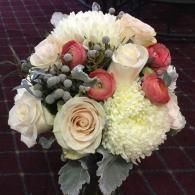Bouquet of white, cream, and pink flowers with green foliage on a dark checkered background