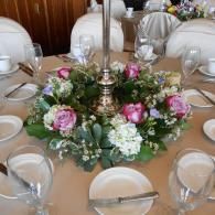 Elegant banquet table with pink and white floral centerpiece, glassware, and place settings