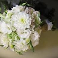 White and pale pink flower bouquet on a beige surface