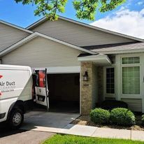 A white van is parked in front of a house.