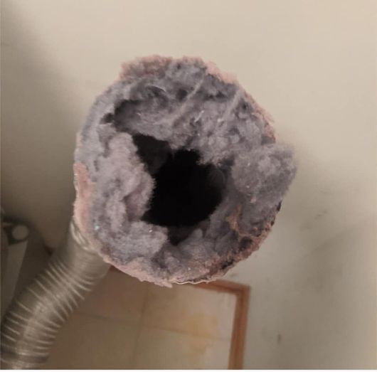 A close up of a dryer vent duct needing cleaning services. 