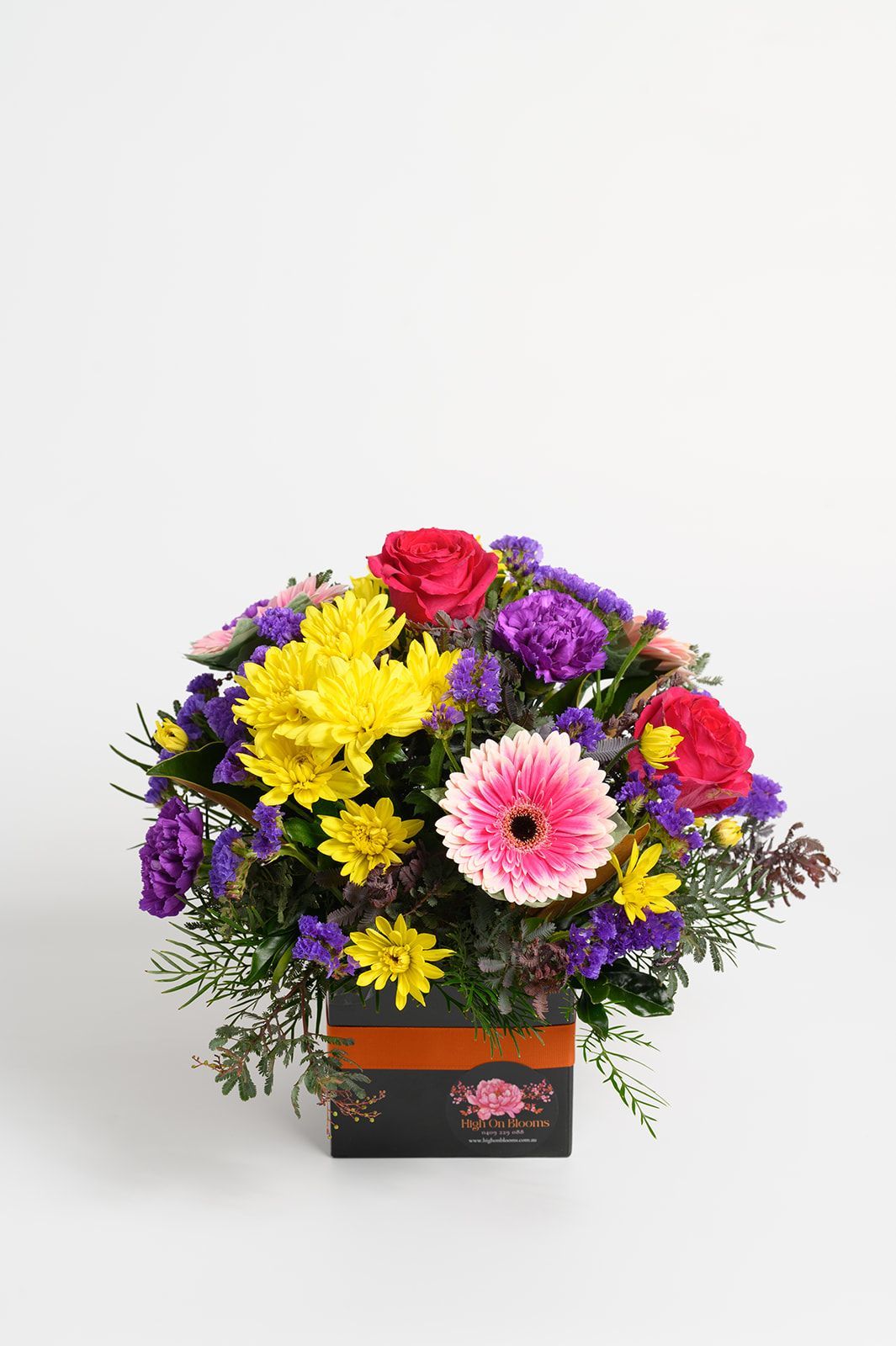 Colorful mixed bouquet of flowers in a black gift box on a white background