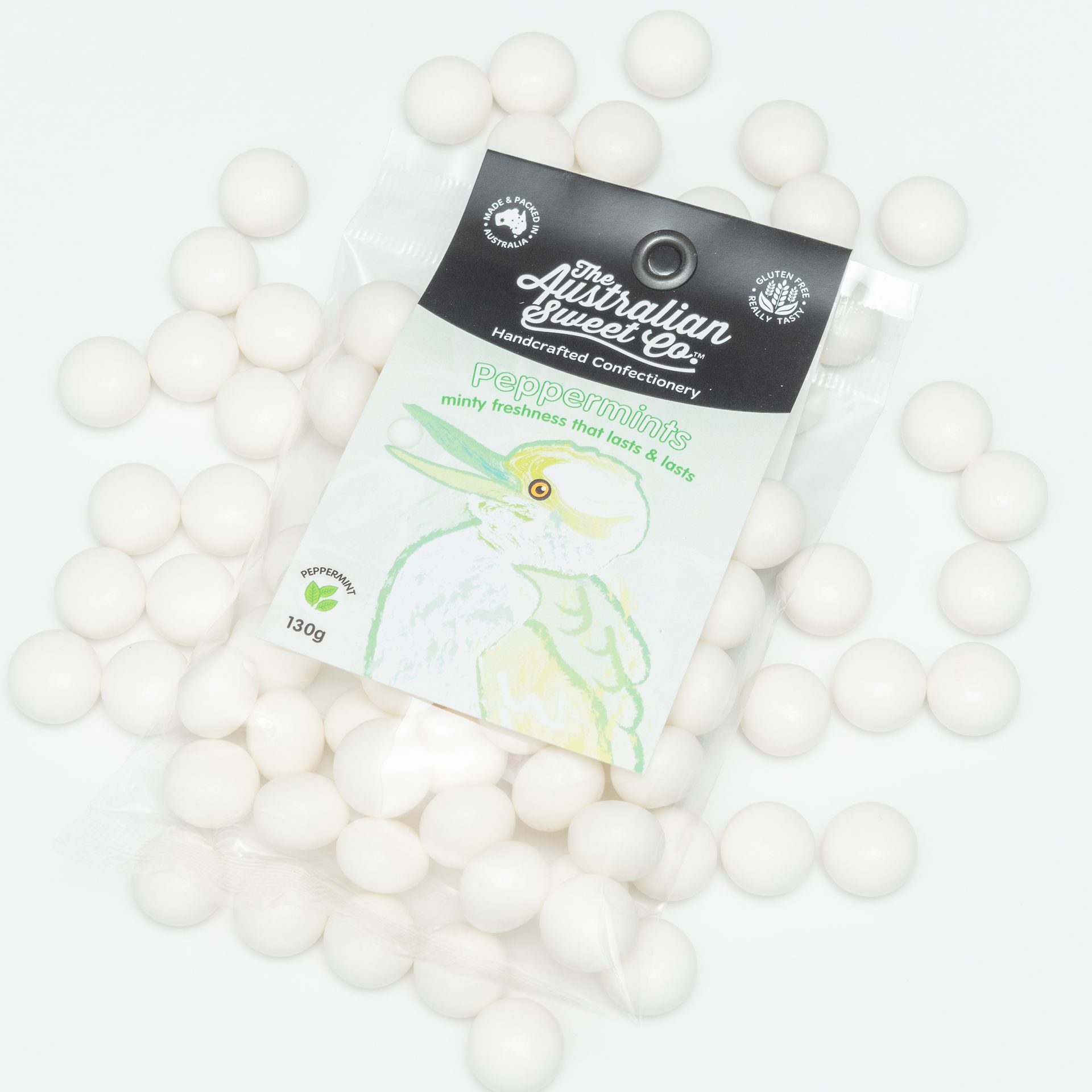 Black-and-white product package surrounded by scattered white round pellets on a white background