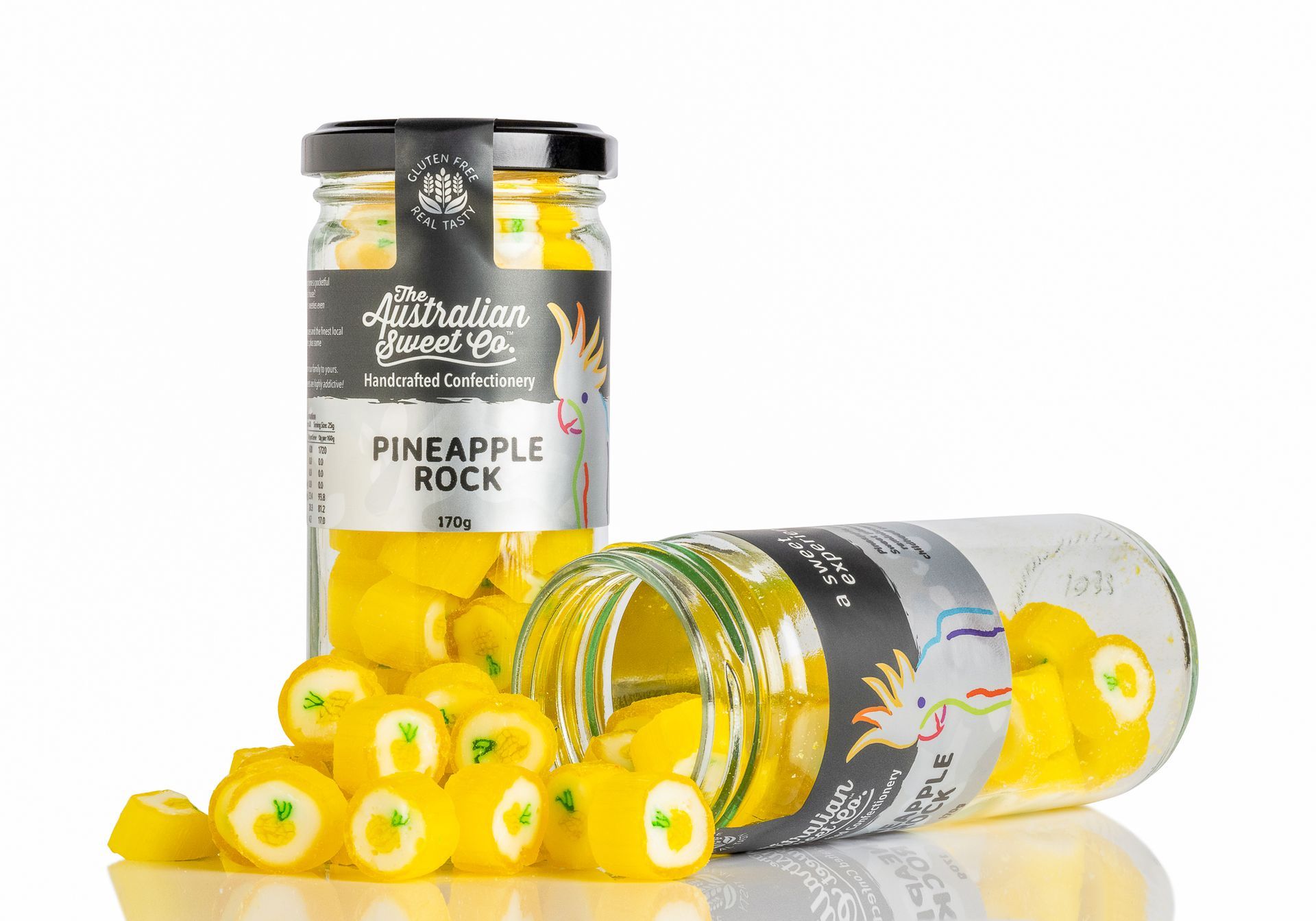 Pineapple Rock candy jars with yellow and white round candies, one jar upright and one tipped over