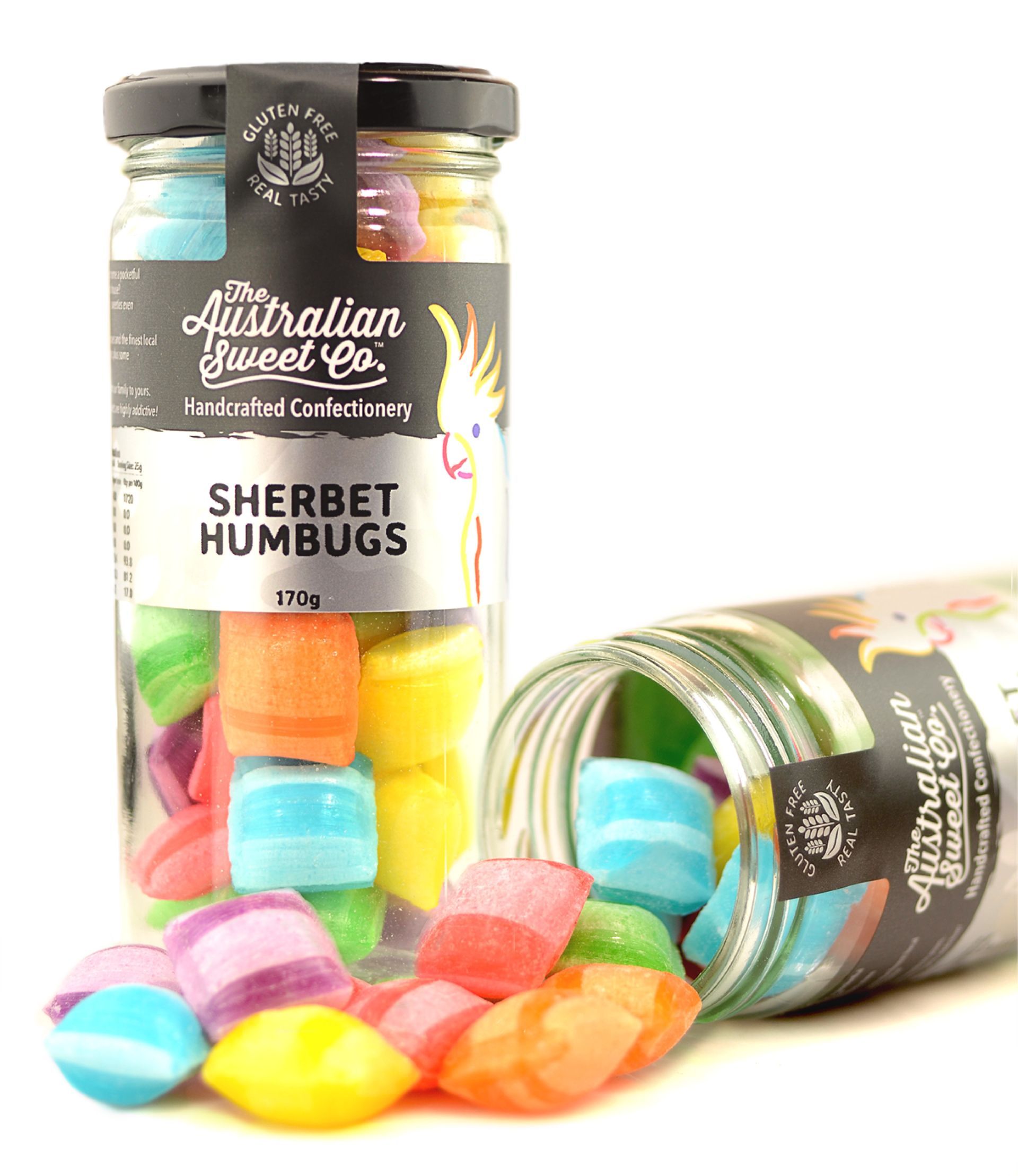 Two jars of Australian Queen sherbet humbugs, one upright and one tipped, with colorful candies spilling out.