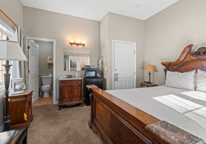 A bedroom with a king size bed and a bathroom