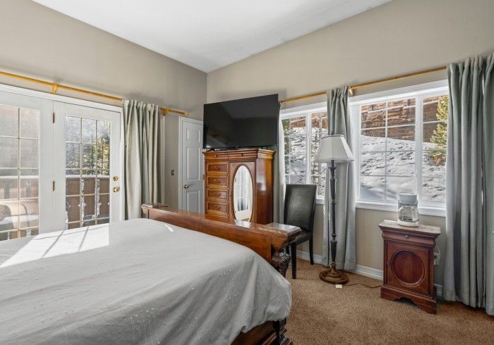 A bedroom with a bed , dresser , nightstand and television.