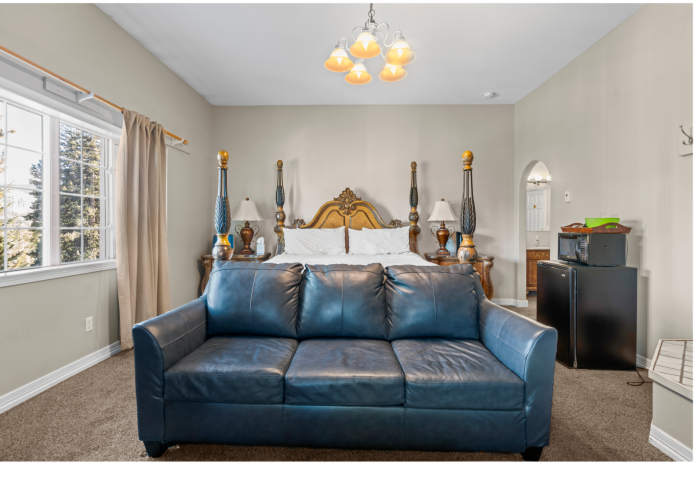A bedroom with a blue couch and a bed