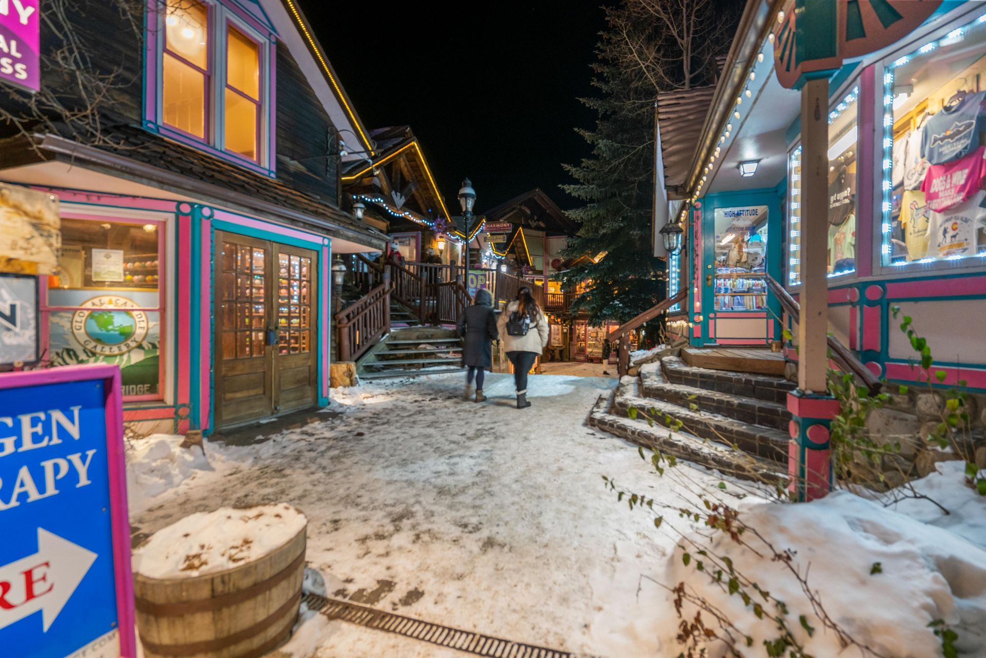 A couple of people are walking down a snowy street.
