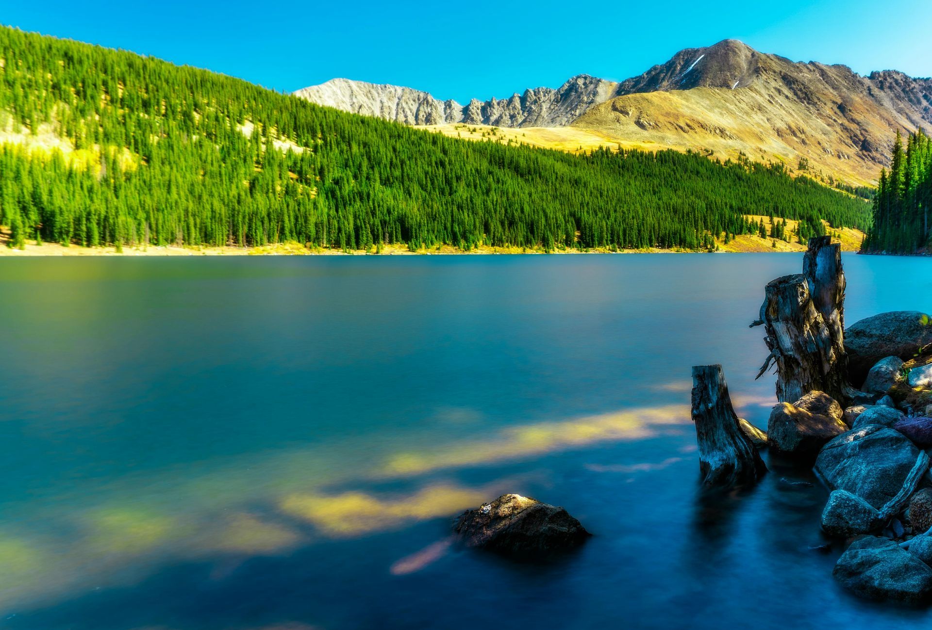 A lake with mountains in the background and trees on the shore