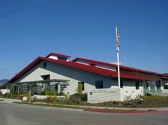 Fire station with red roof and American flag against a blue sky.