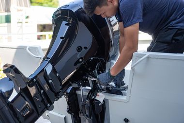Technician winterizing a boat at a marina dock