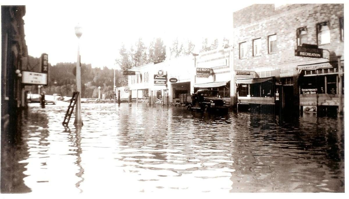 Historical photograph of a Bonners Ferry flood, downtown buildings reflected in floodwater, from the Boundary County Museum collection