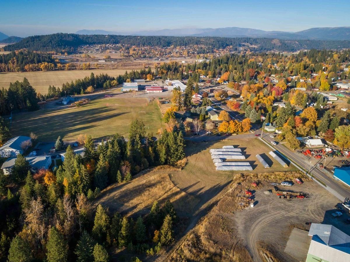 Aerial view of Bonners Ferry in fall with gold trees, rooftops and the mountains beyond