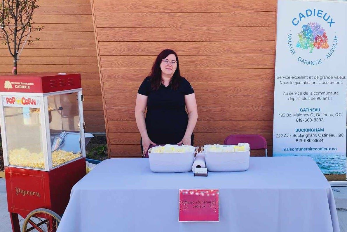 Une femme se tient devant une machine à pop-corn.