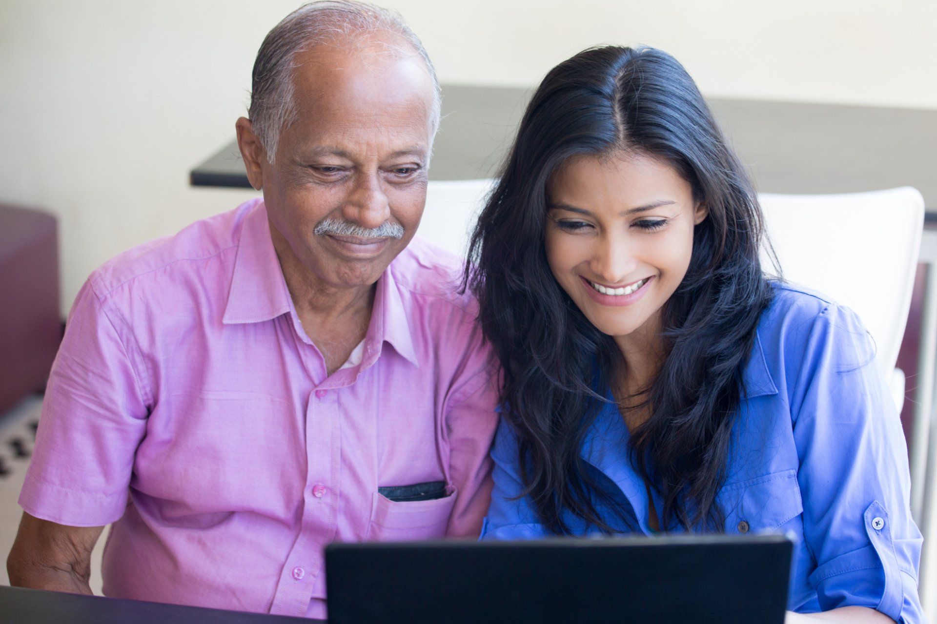 elderly father and adult daughter using a laptop