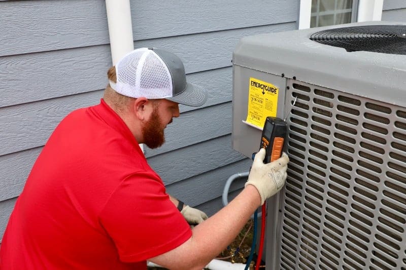 A Man Checking AC Using Multimeter - Wichita, KS - American Services A man performing air conditioning repair in Wichita, KS