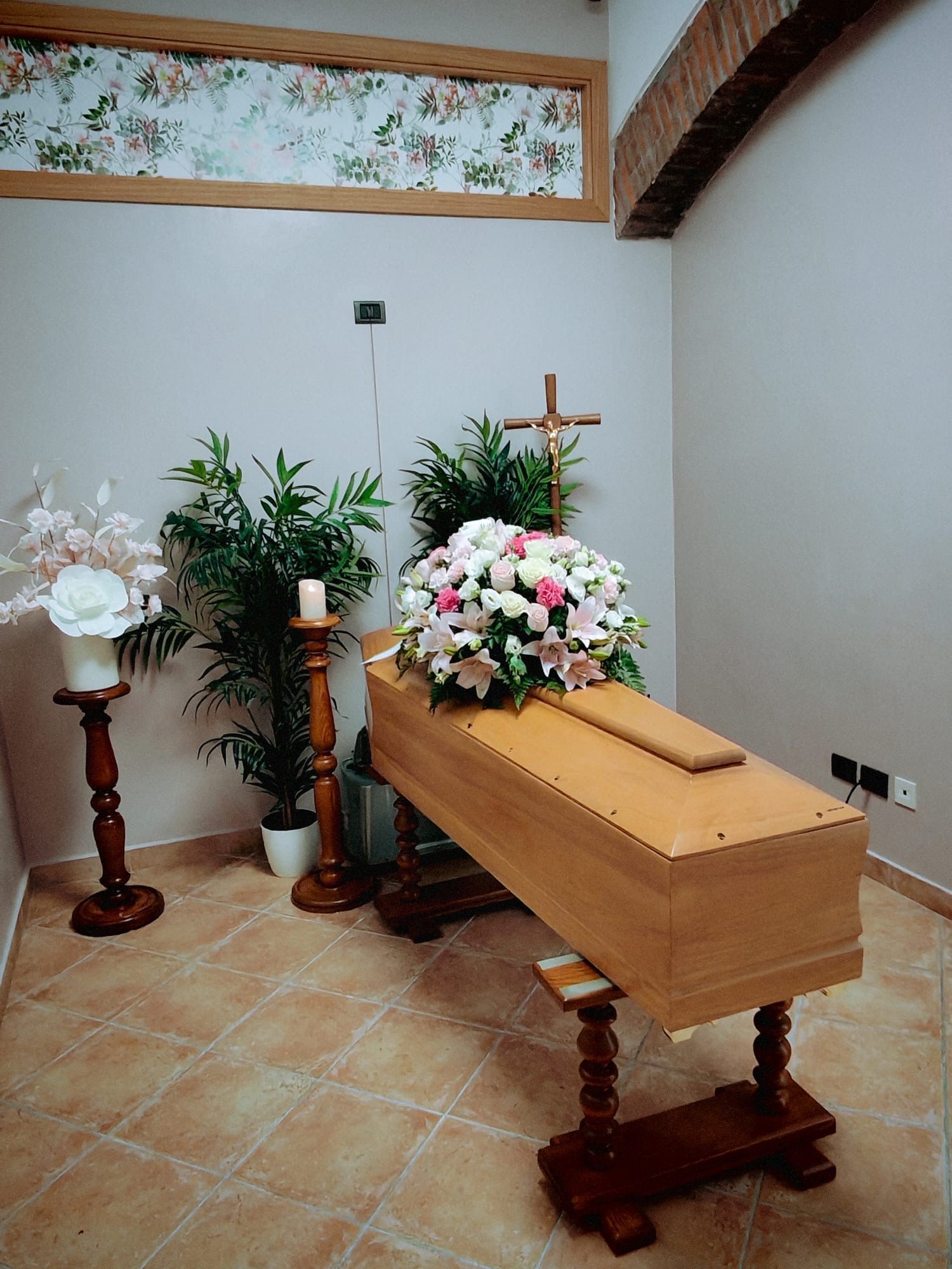 Bara di legno con fiori bianchi e rosa in una semplice stanza di cappella.
