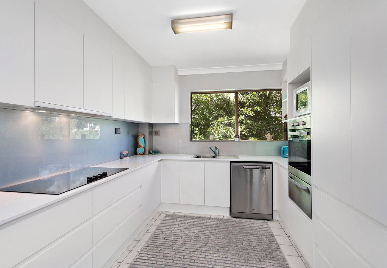 Modern White Kitchen With a Window, Dishwasher, and Stove — Affordable Tiles and Pavers In Morisset, NSW