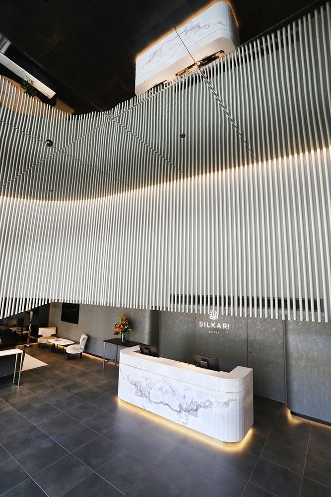 Reception Area With Marble Desk Under Wavy, Vertical Panels — Affordable Tiles and Pavers In Morisset, NSW