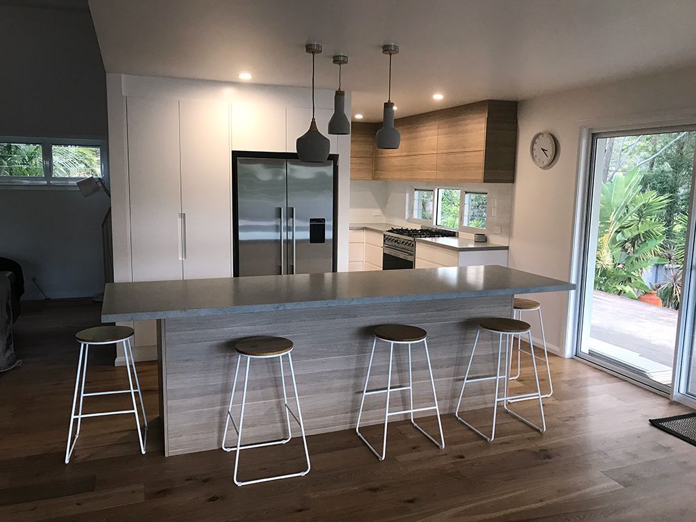 Modern Kitchen With Island, Stools, Wood Floors, and Pendant Lights — Affordable Tiles and Pavers In Morisset, NSW