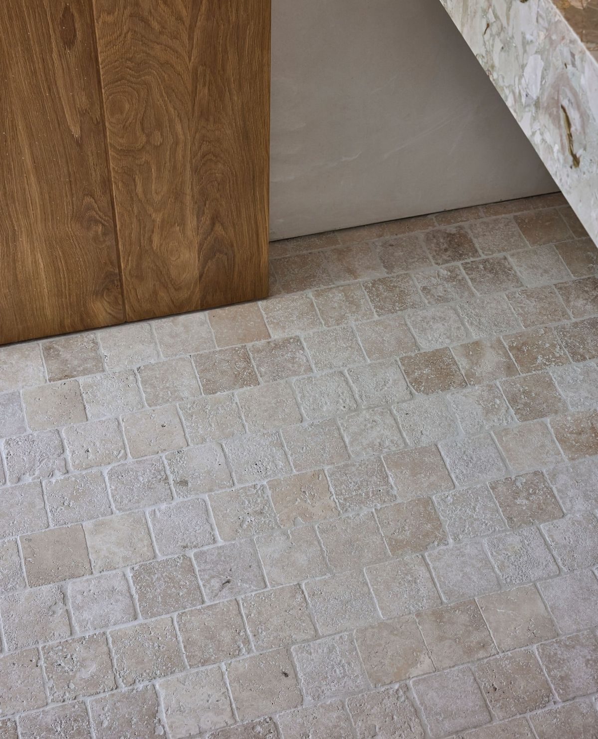 Partially open wooden door beside a beige tiled floor in an indoor room