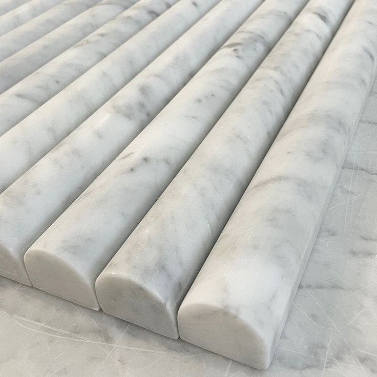 White marble slabs stacked diagonally on a light gray surface