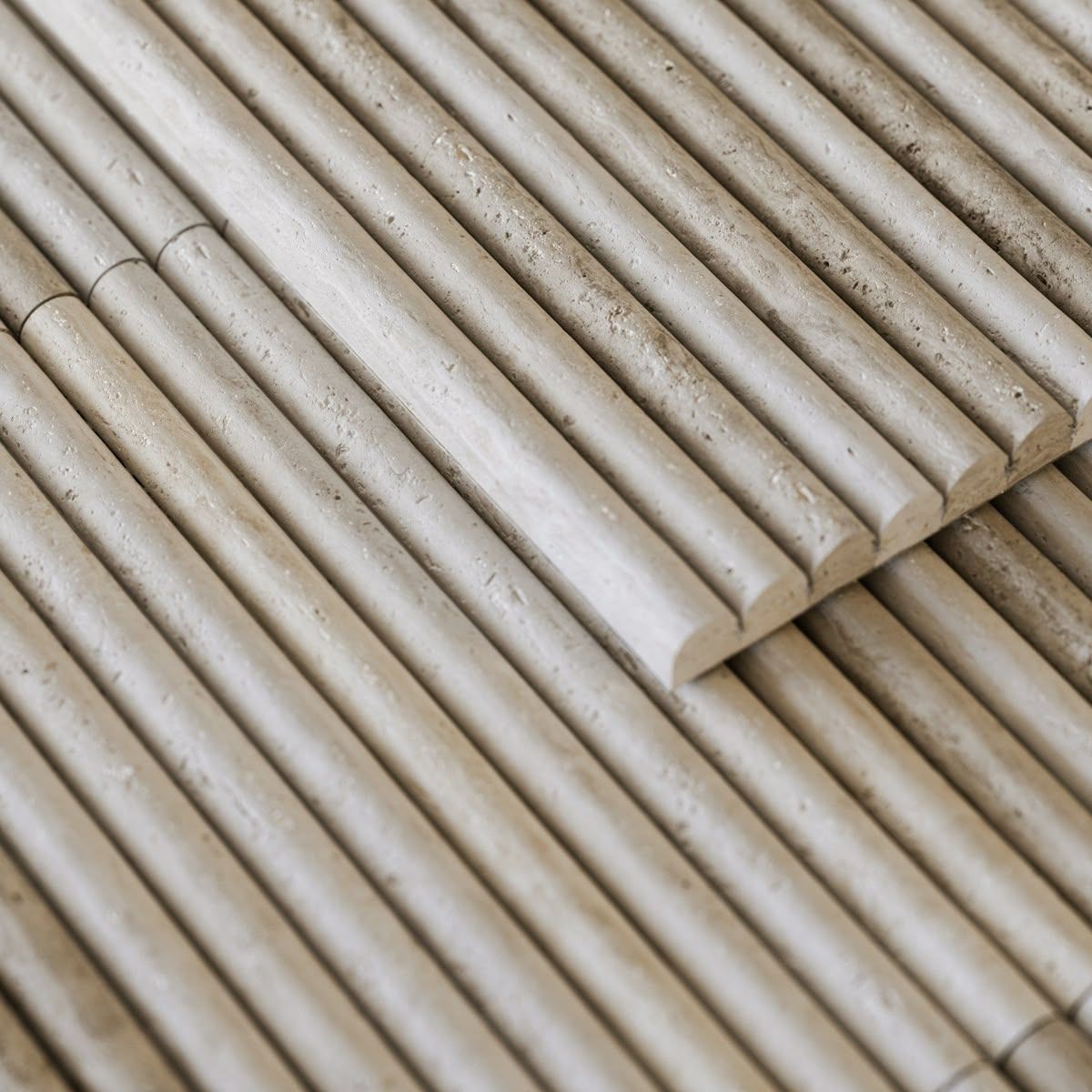 Close-up of beige bamboo mats stacked diagonally in overlapping rows