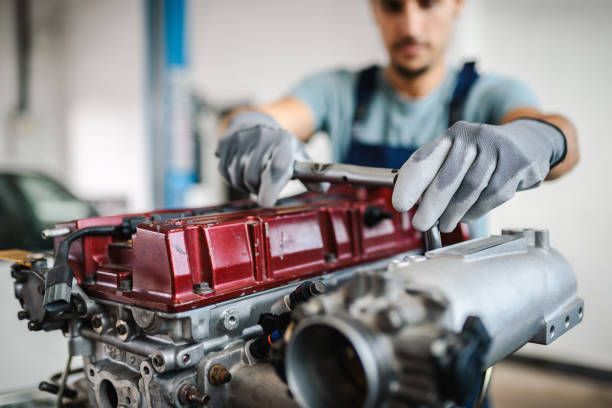 Young car mechanic working on a car engine.