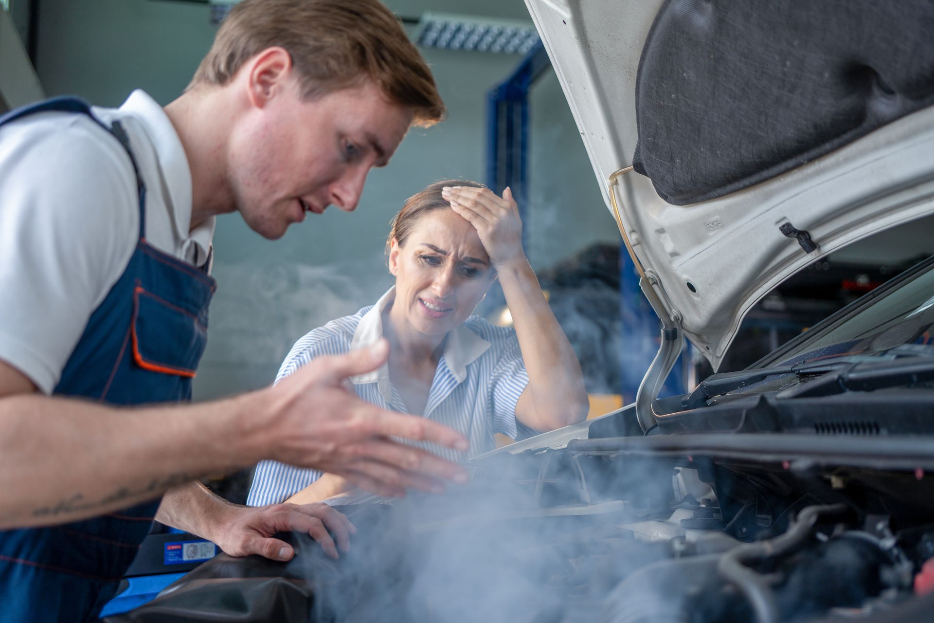 Auto mechanics working on an overheated car engine.