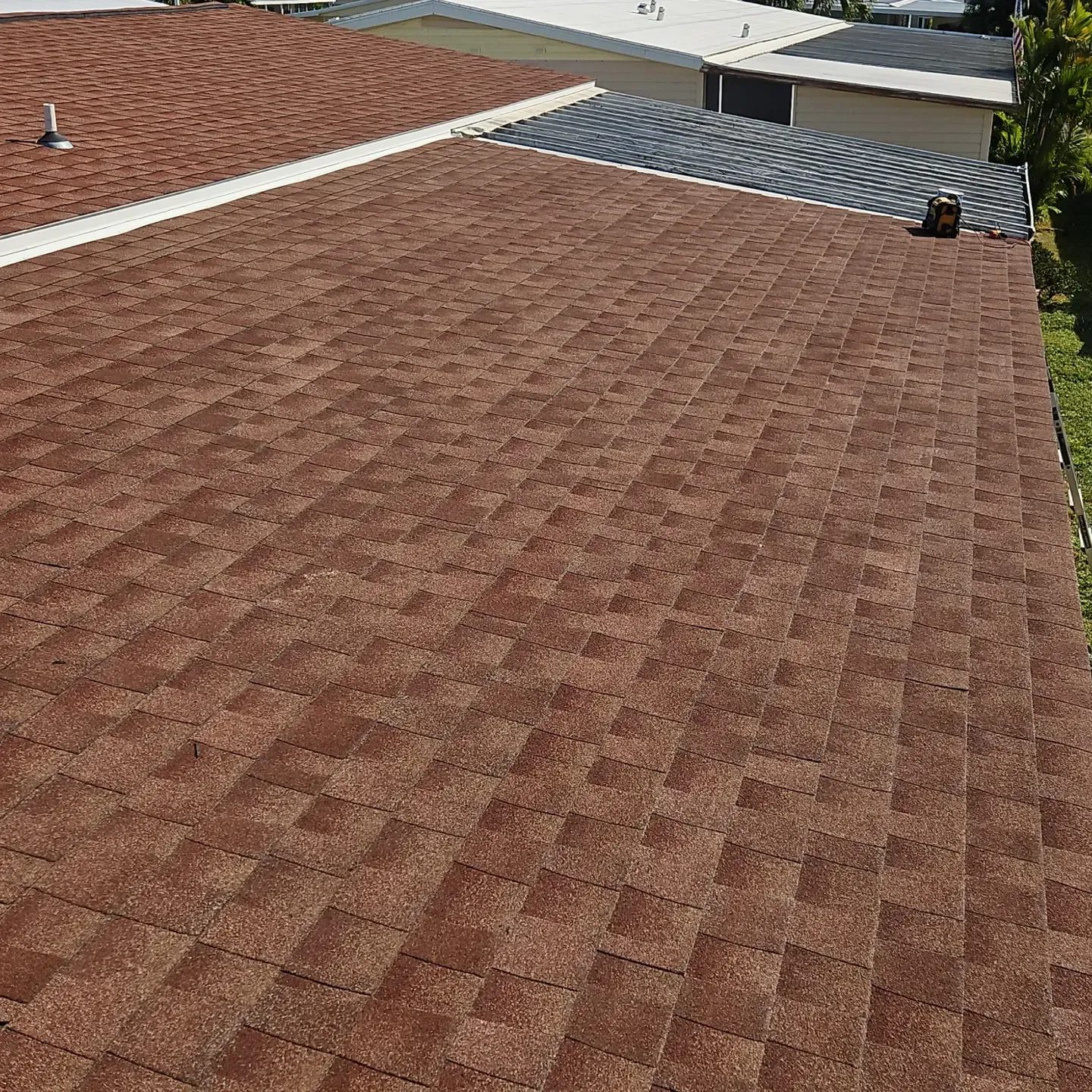 Brown shingle roof with a small gray vented section near the top edge