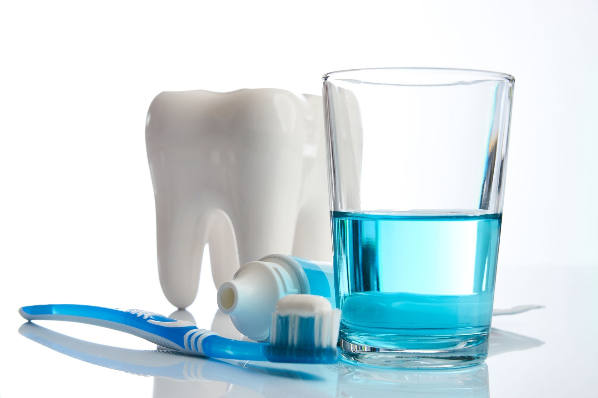 Toothbrush, toothpaste, water glass, and tooth, symbolizing dental hygiene