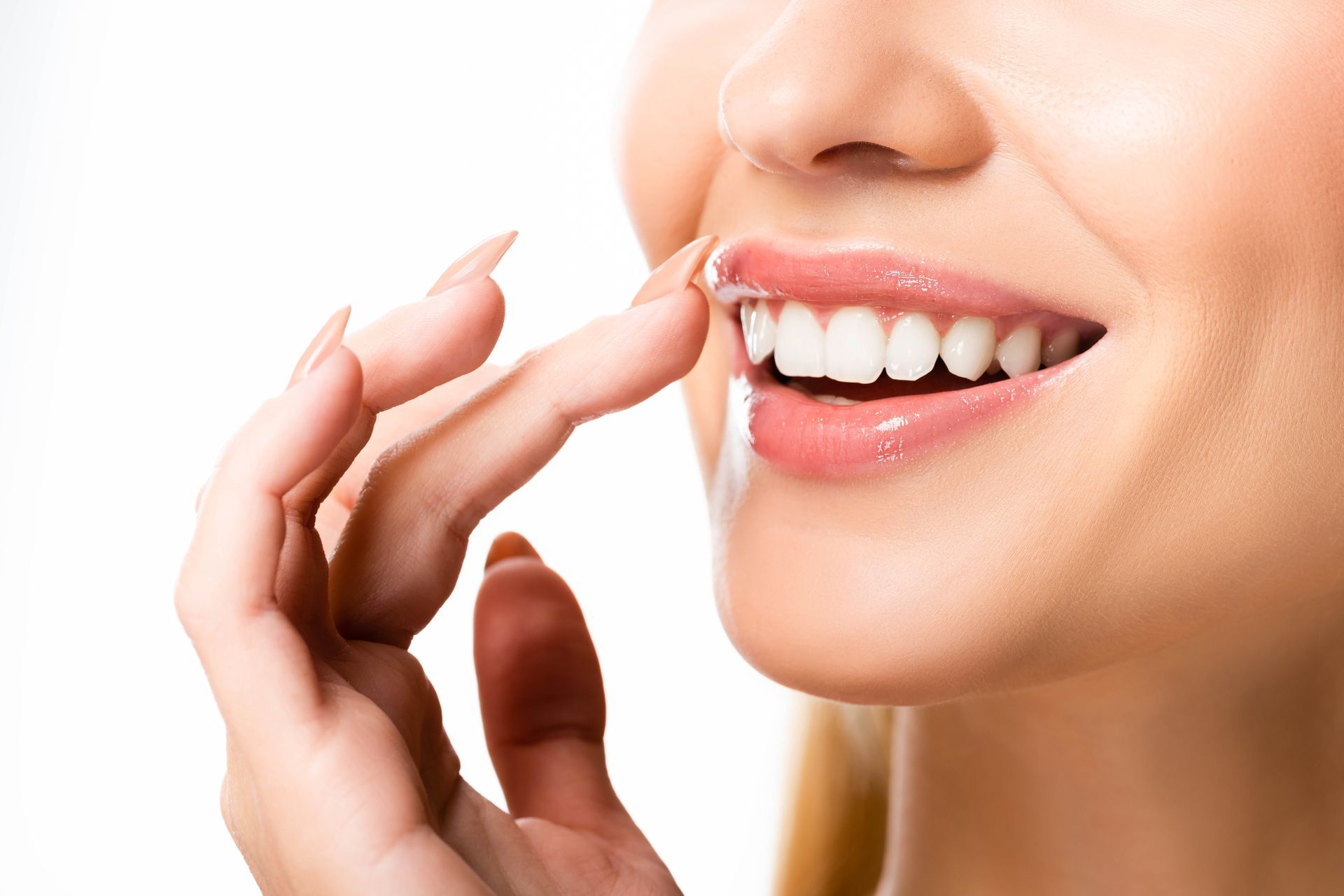 Woman applying clear lip gloss to a smiling mouth close-up