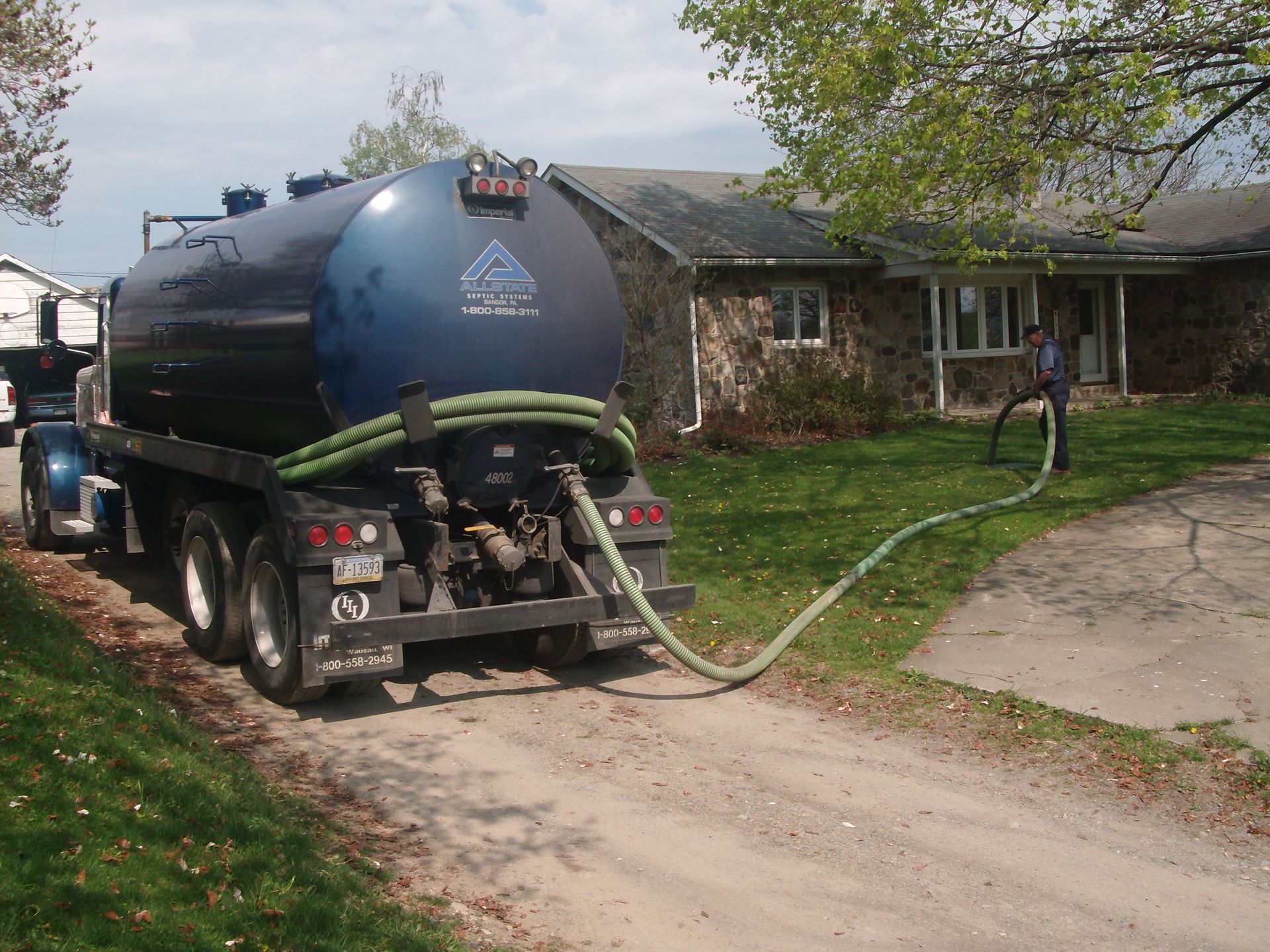 Septic pumping service truck cleaning a residential septic system
