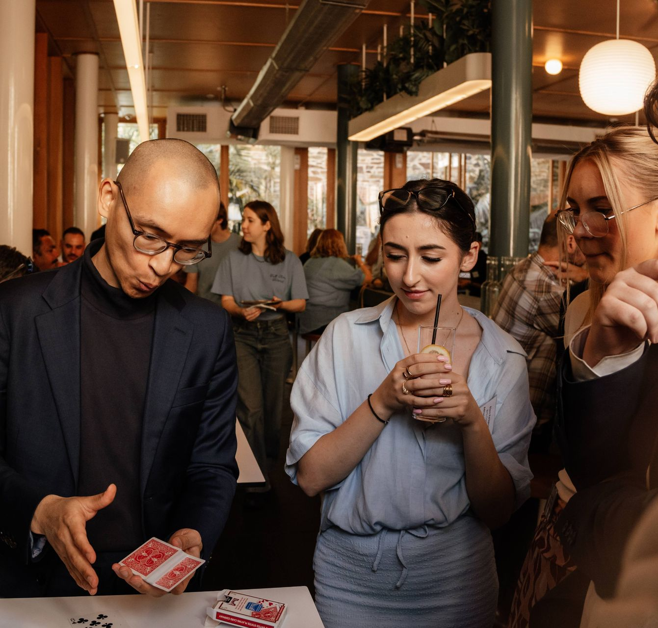 Roving magician Adelaide entertaining guests at cocktail party