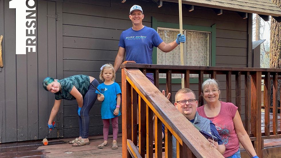 A family is standing on a porch of a house.