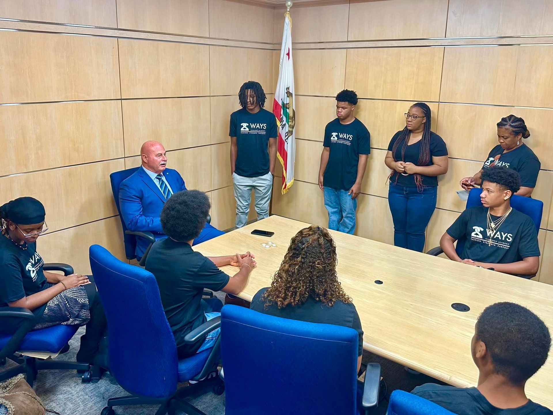 A group of people are sitting around a table in a conference room.