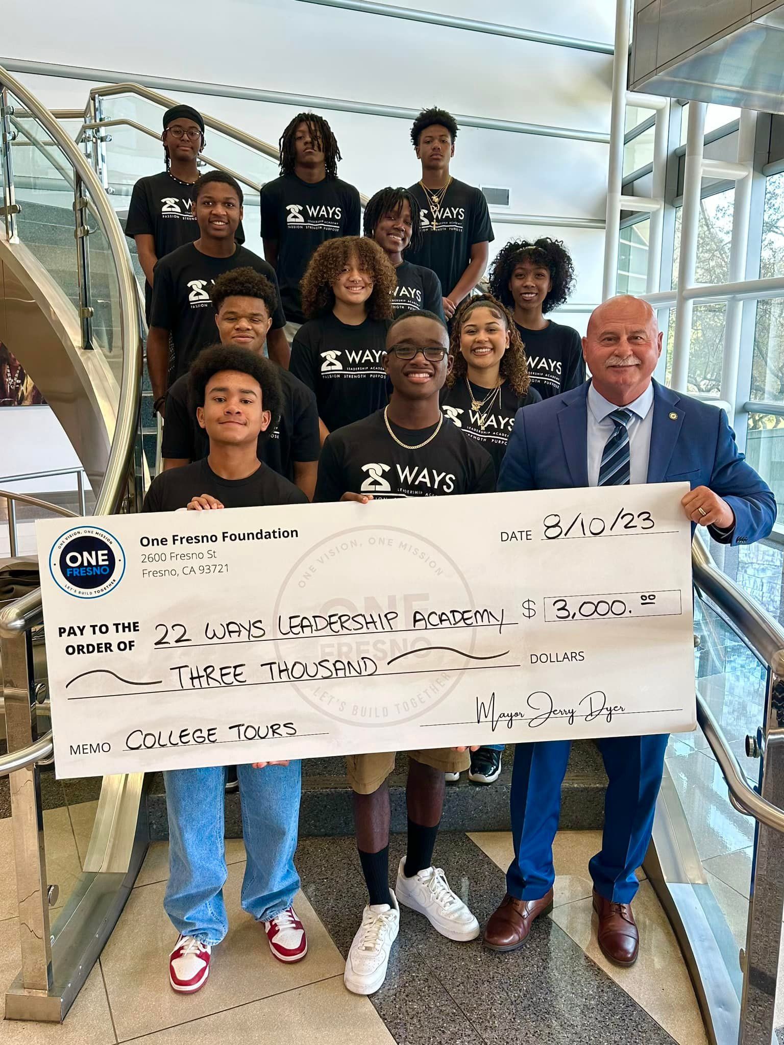 A group of people standing next to each other holding a large check.