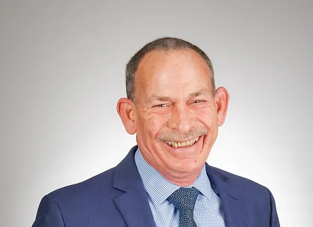 A man in a suit and tie is smiling for the camera.